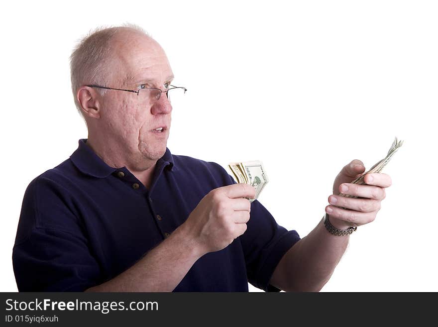 An older bald guy in a blue shirt counting out money. An older bald guy in a blue shirt counting out money