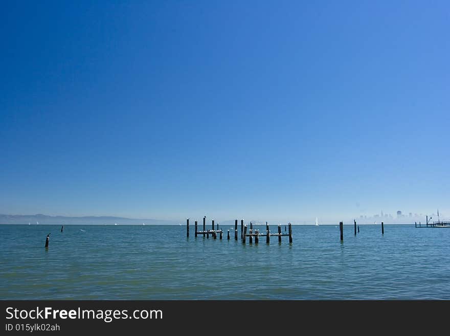 Sea poles with the city of San Francisco in the back with fog surrounding it