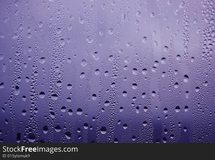 Water drops on a blue glass