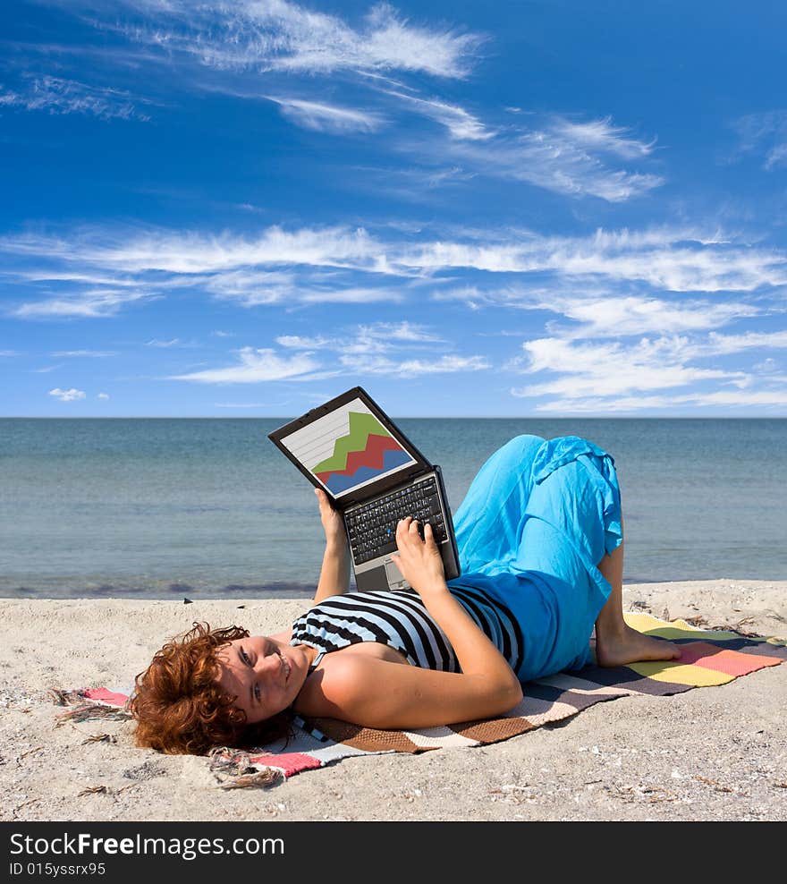 Girl working on laptop near of sea