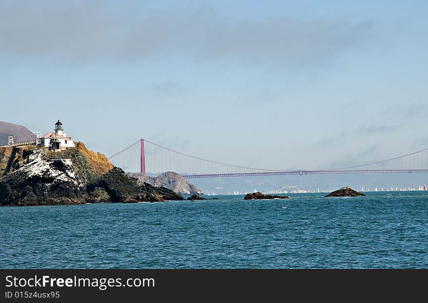 Old lighthouse with Golden Gate bridge in background