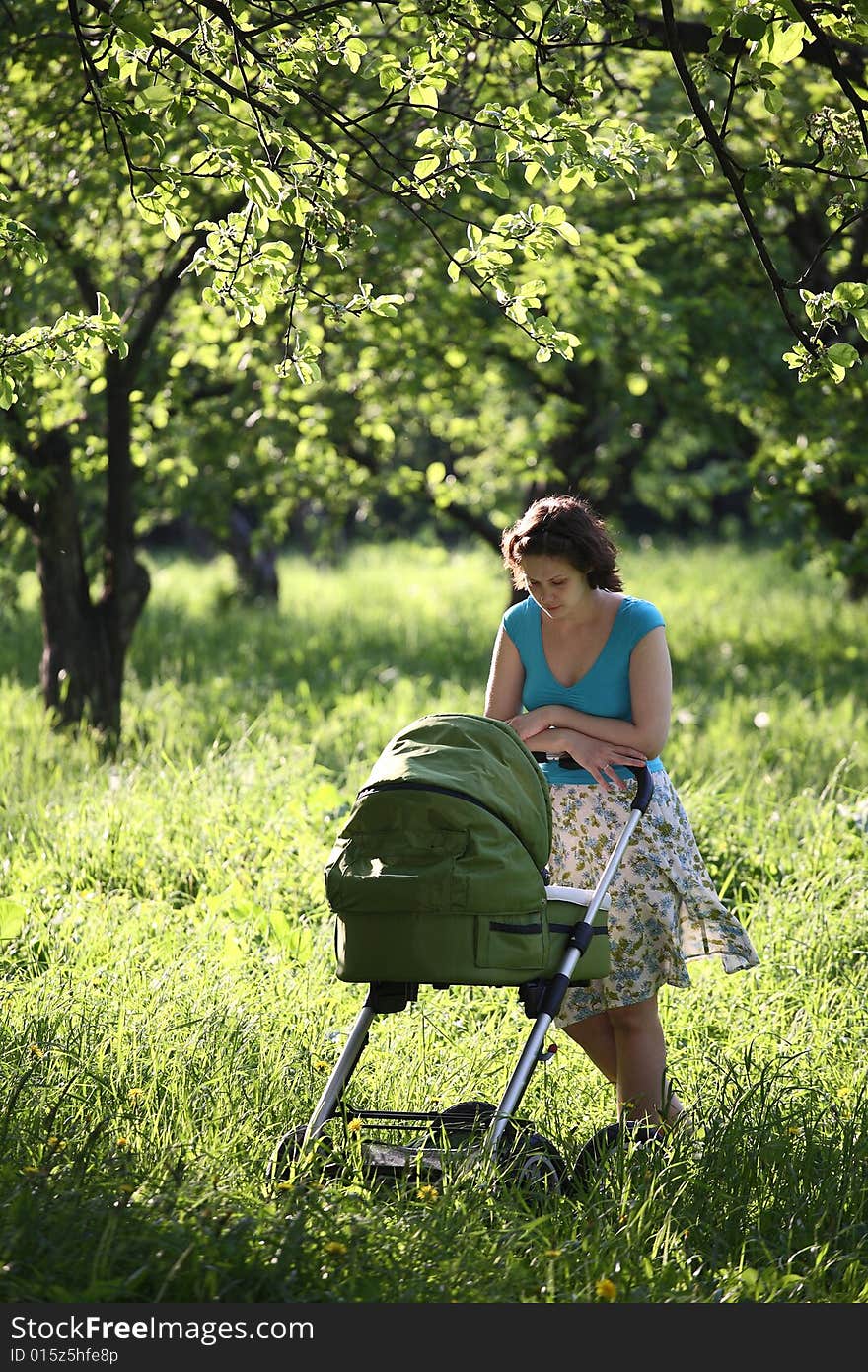 Mother with baby carriage in the park