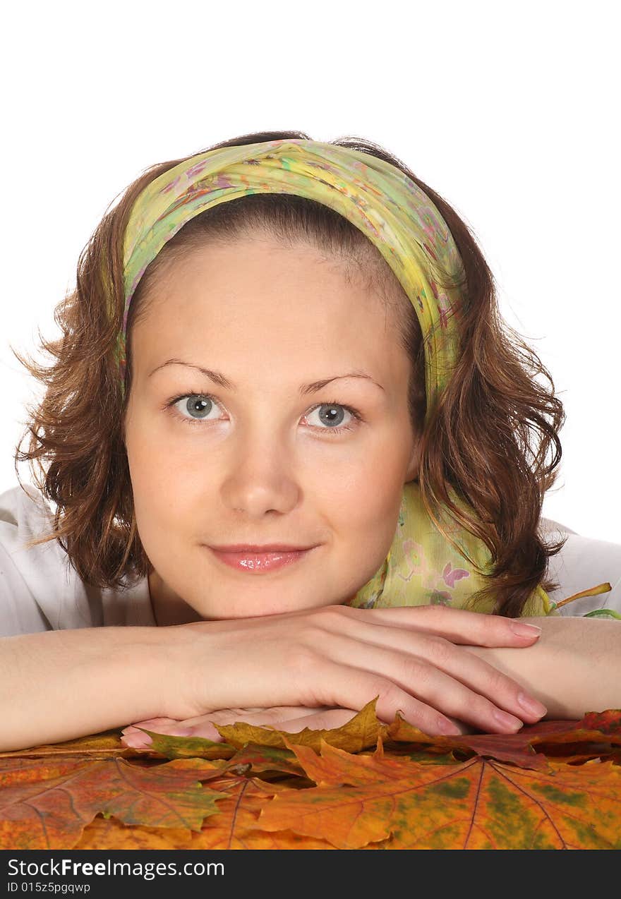 Portrait of Beautiful model with green scarf relaxing on maple leaves