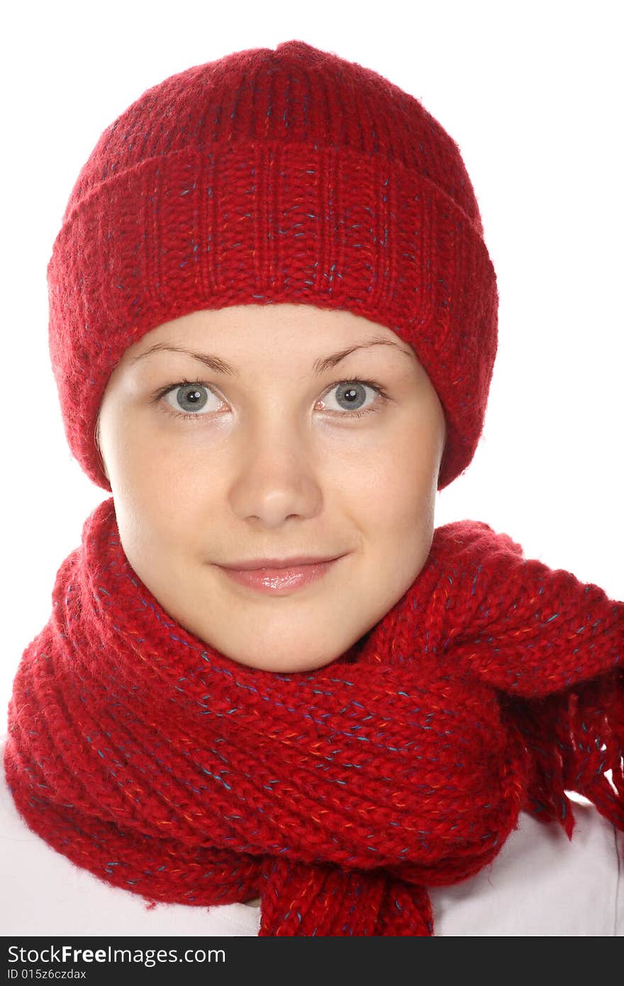 Beautiful girl with blue eyes in red knitted cap and scarf