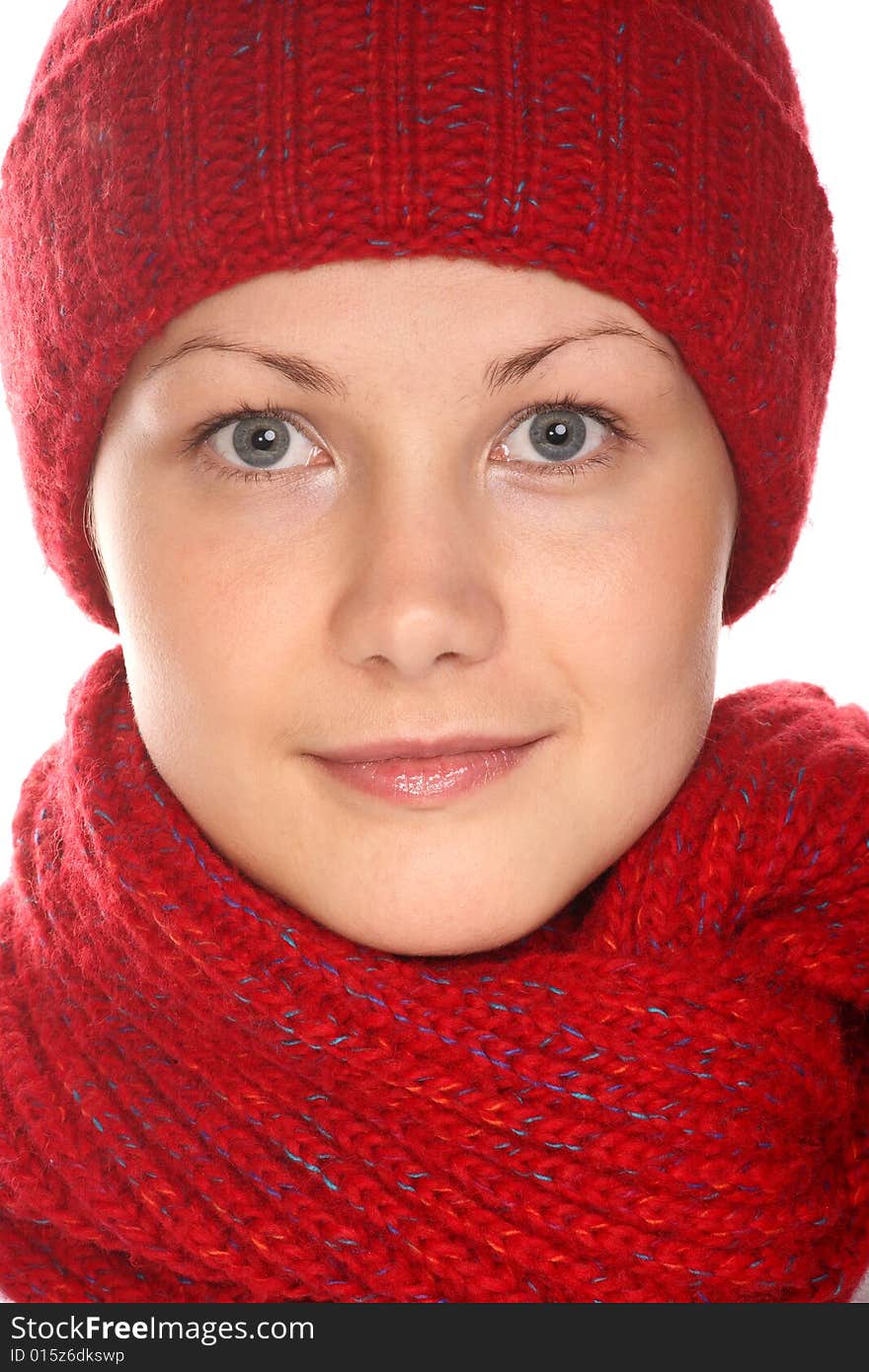 Beautiful girl with blue eyes in red knitted cap and scarf