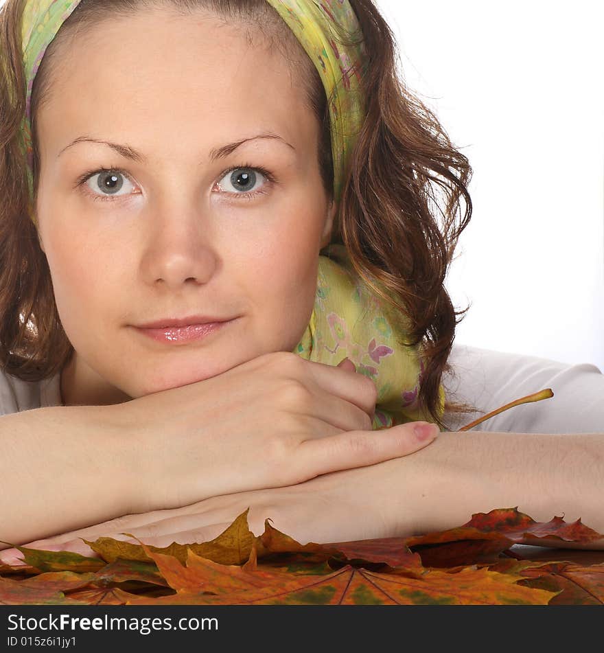 Portrait of Beautiful model with green scarf relaxing on maple leaves