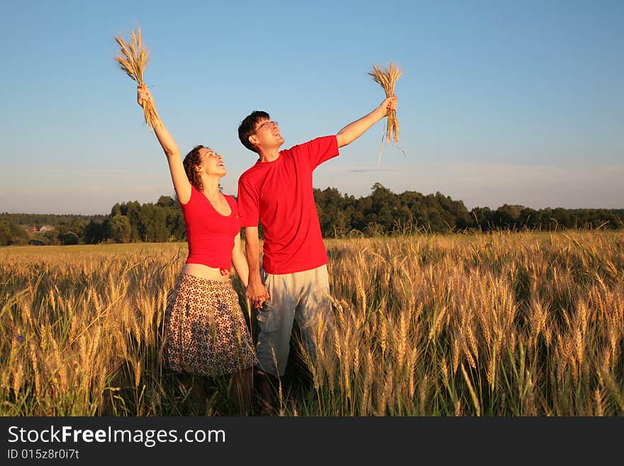 Pair in field with wheat in hands