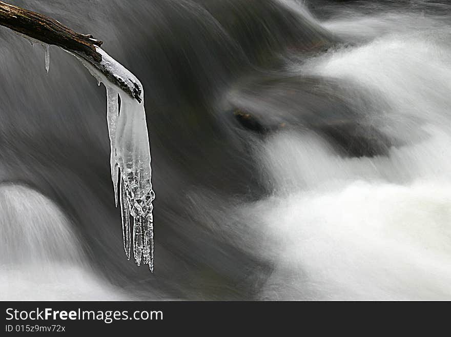 Icicle on branch over mountain stream