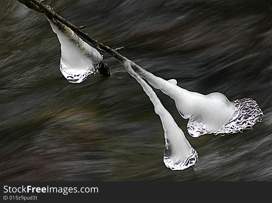 Icicle on branch over mountain stream