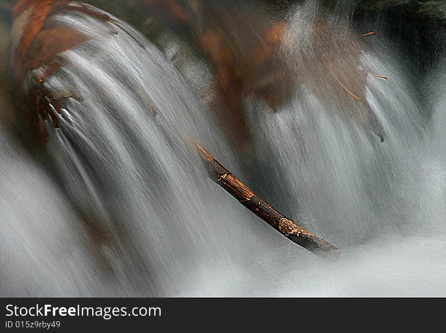 Single, isolated branch in fast flowing mountain stream in winter. Single, isolated branch in fast flowing mountain stream in winter