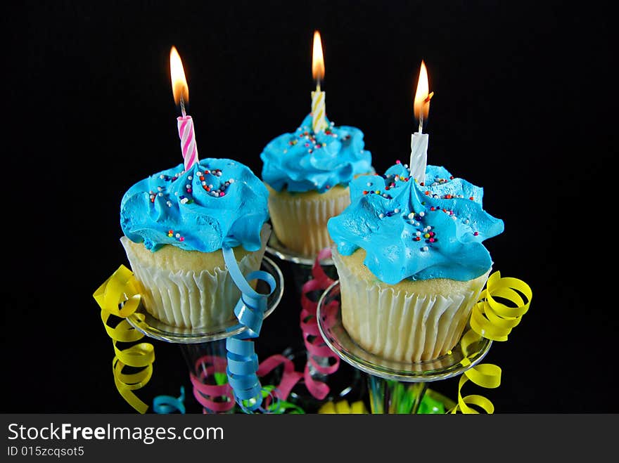 Iced cupcakes and ribbons on pedestals. Iced cupcakes and ribbons on pedestals.