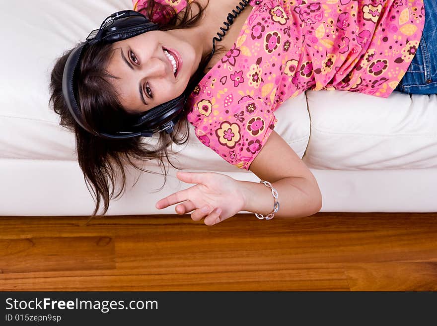 Beautiful young woman listening music with headphones isolated on white