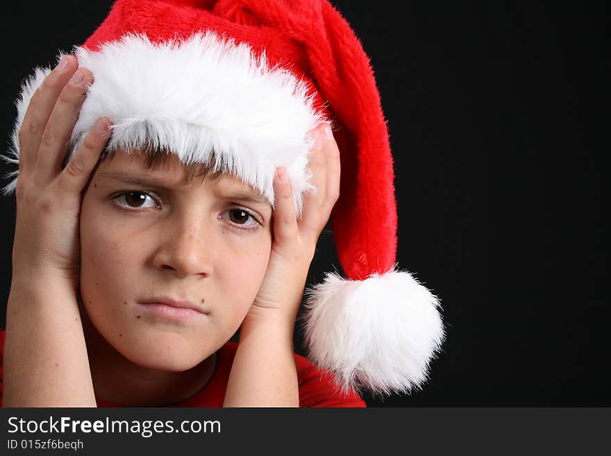 Young boy wearing a red shirt and christmas hat. Young boy wearing a red shirt and christmas hat