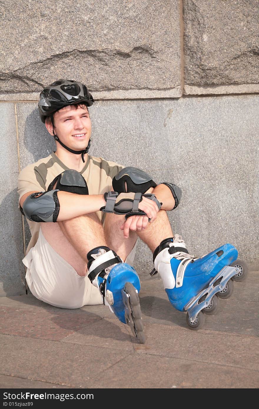 Roller sits under stone wall, outdoors