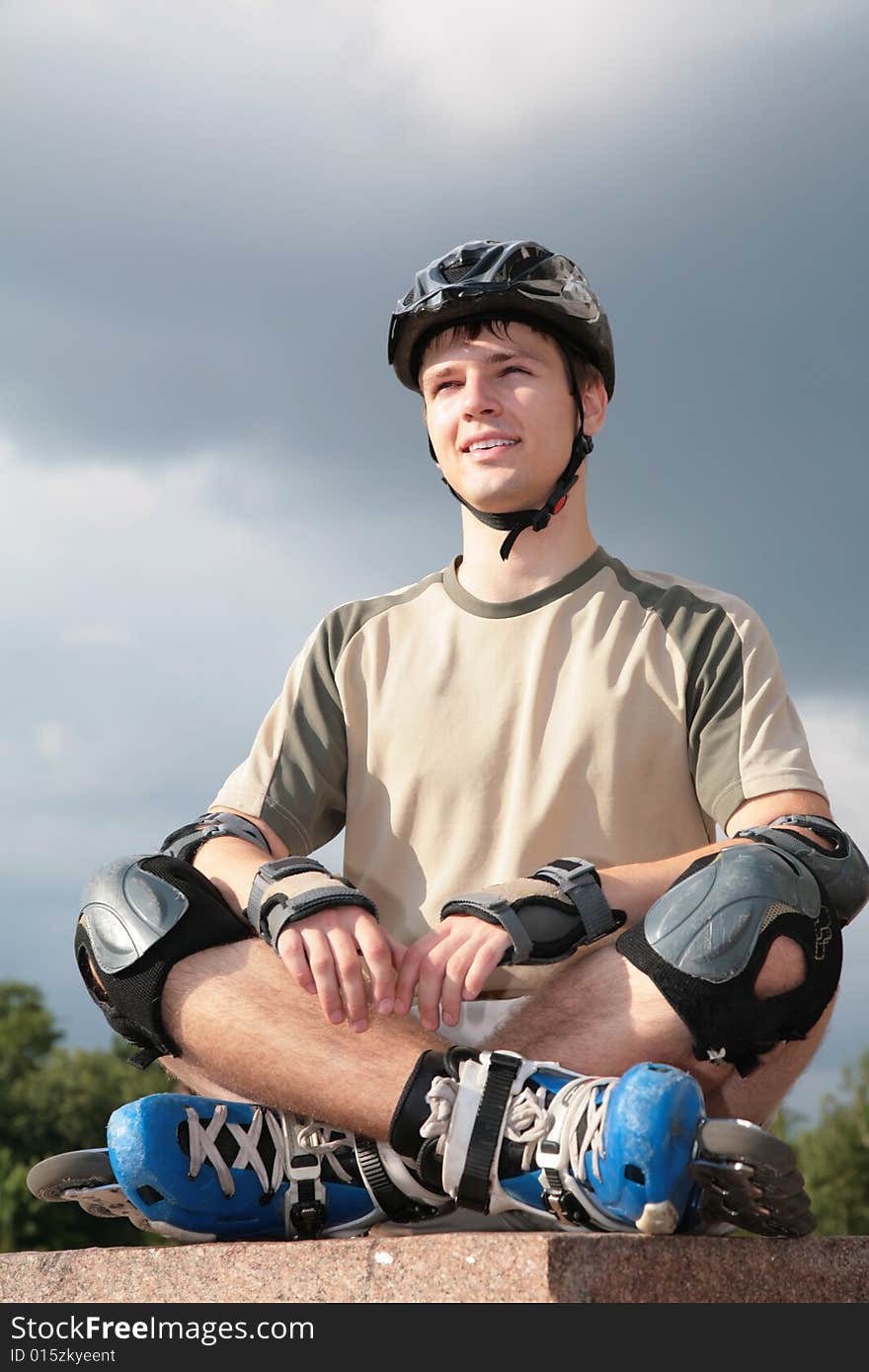 Boy On Rollerblades Sits With Crossed Legs In Yoga