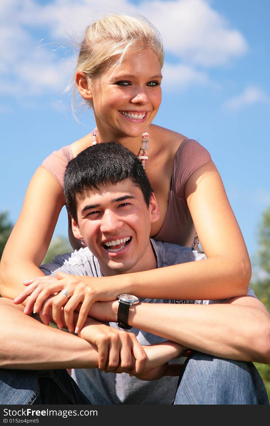 Girl embraces boy from back on sky