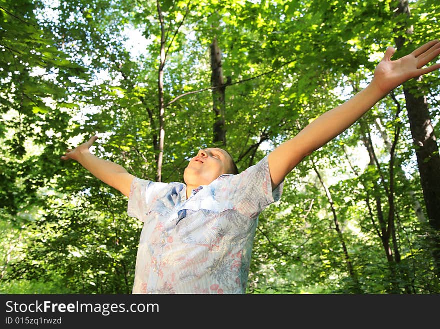 Guy in dark wood with rised hands. Guy in dark wood with rised hands