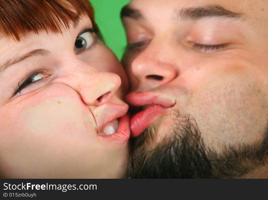 Close up girl with red hair and guy grimace on green