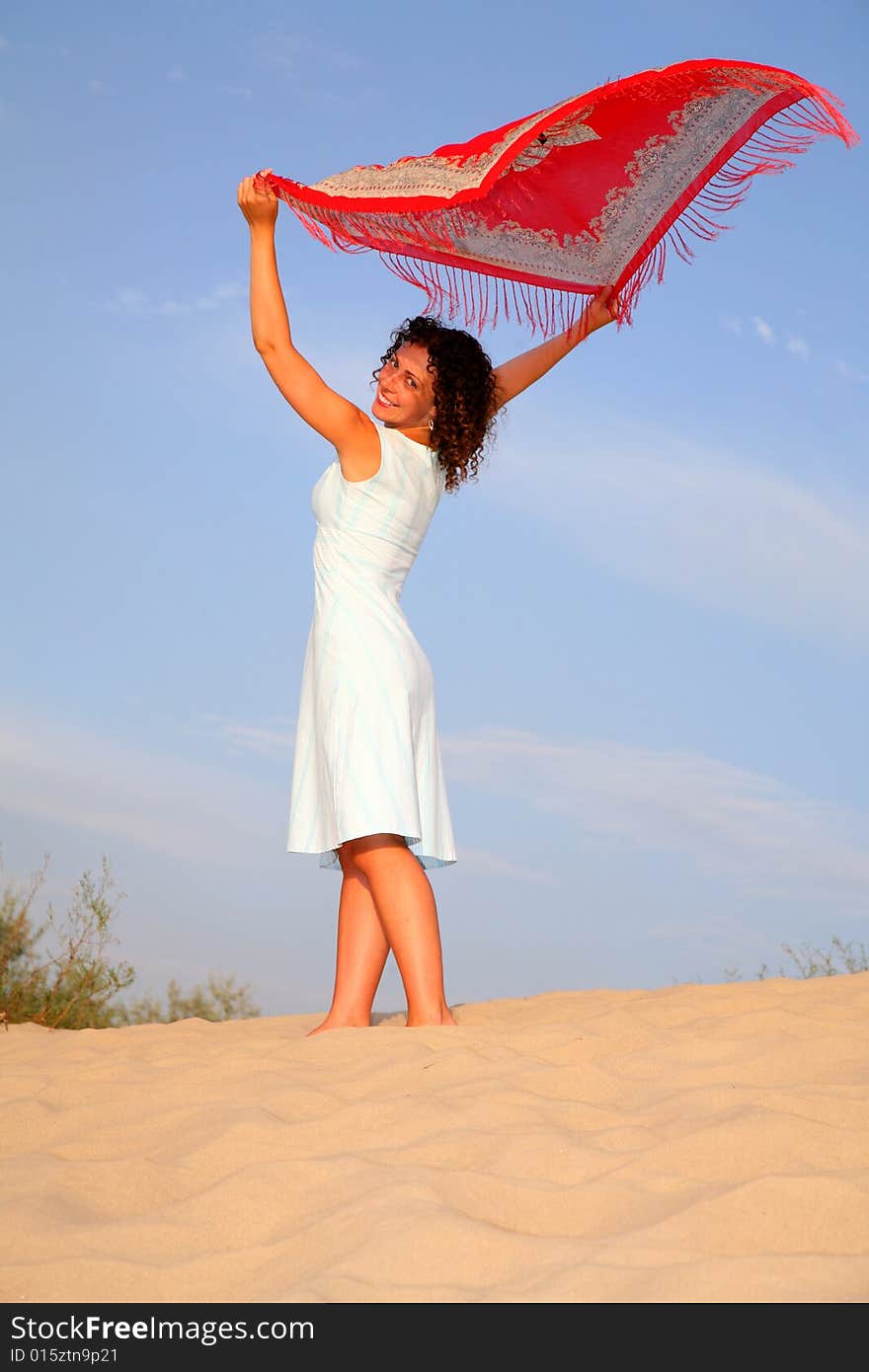 Girl on sand with shawl in hands