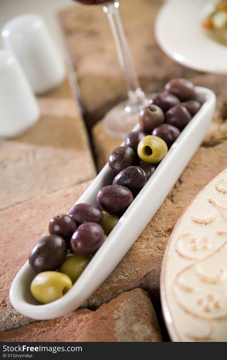 Olives on brick table with glass, shallow depth of field. Olives on brick table with glass, shallow depth of field