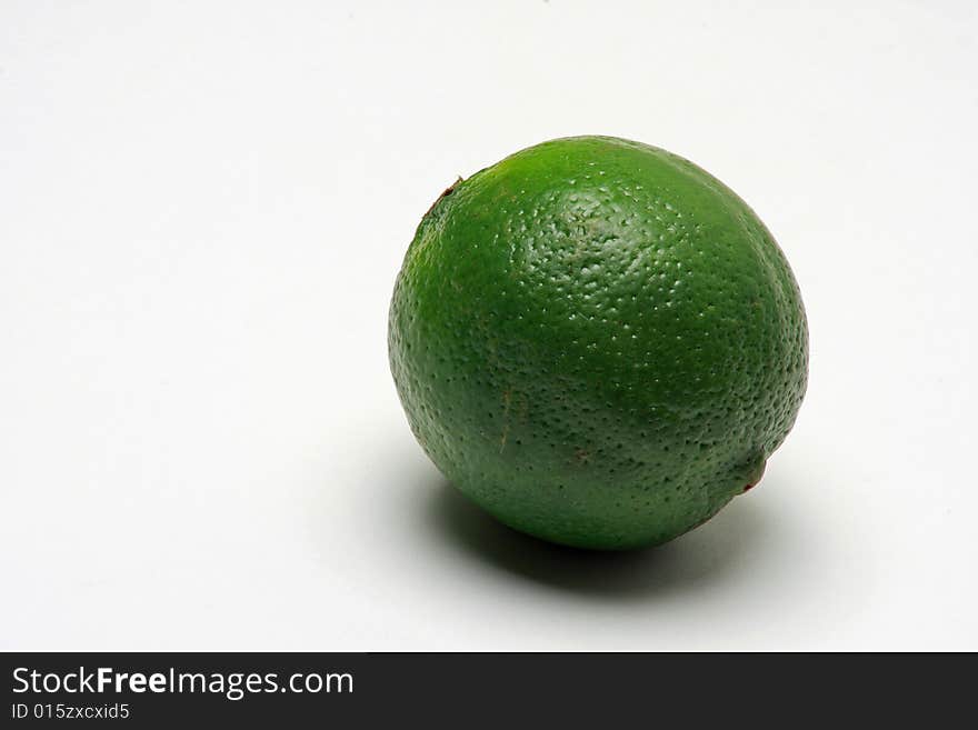 Close up of green lime on white background