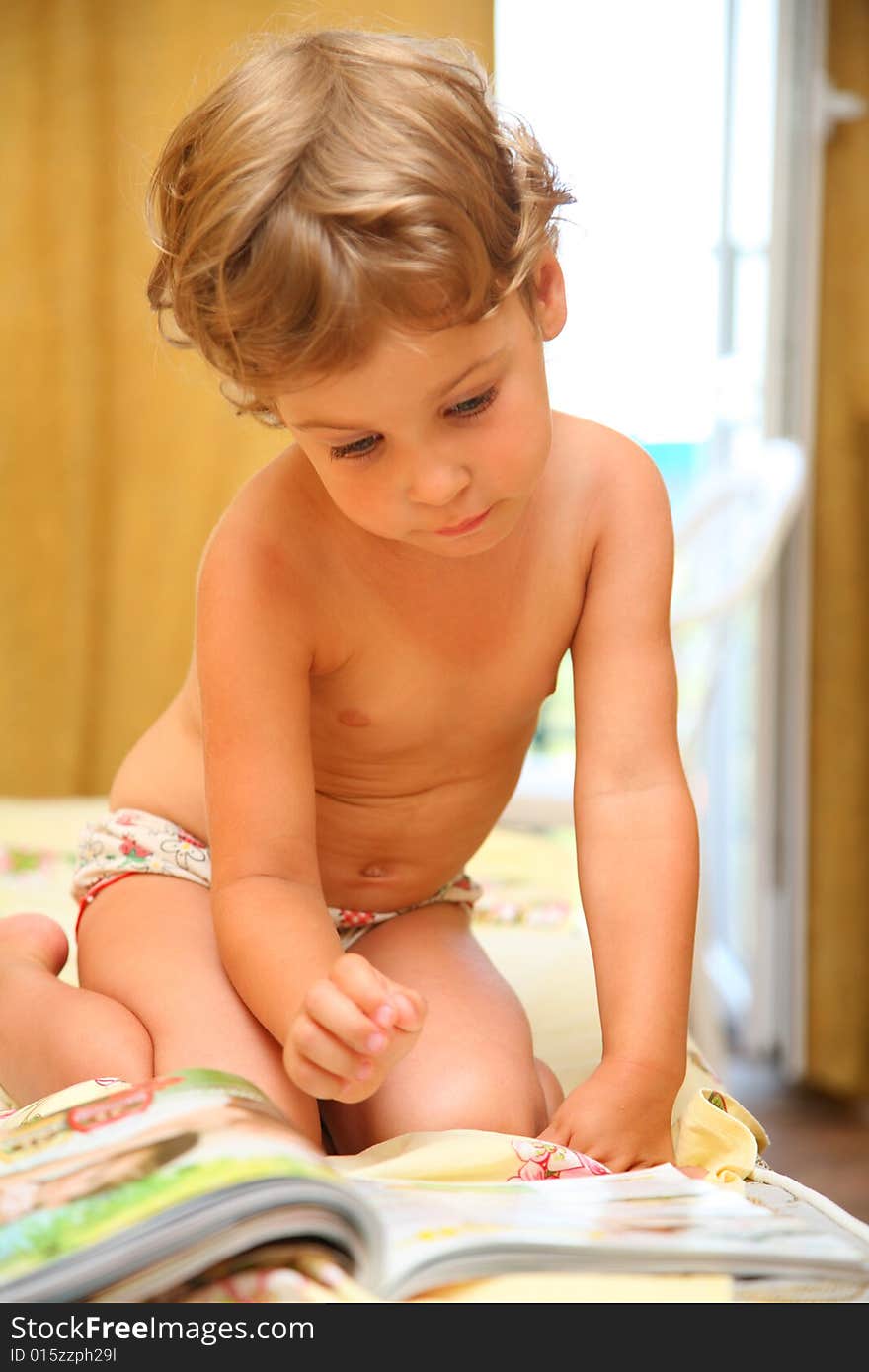 Portrait of little girl reads magazine