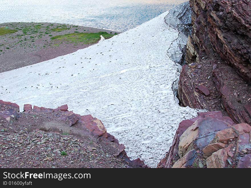 Snow residue surrounded by colorful rocks