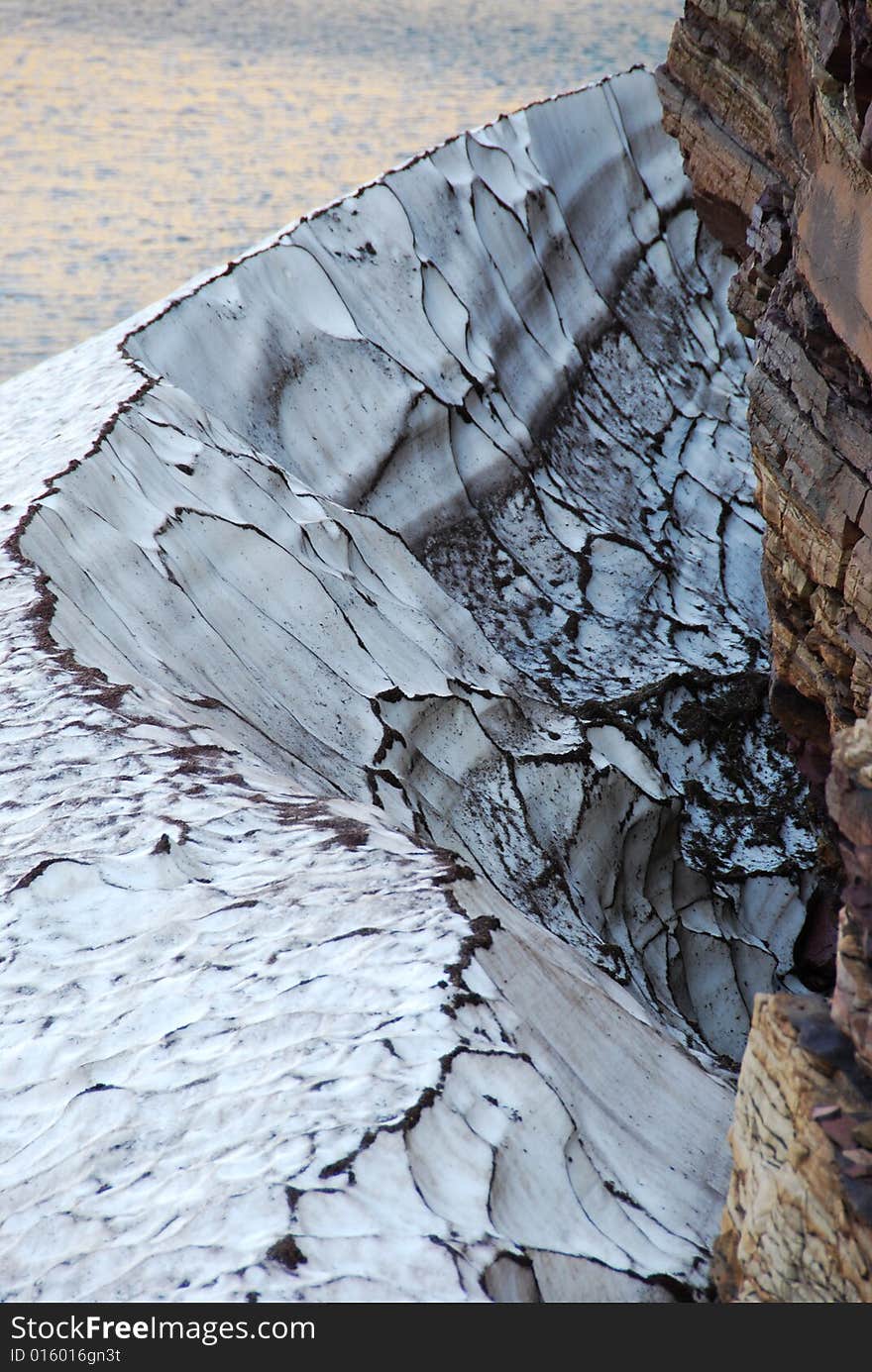 Snow residue surrounded by colorful rocks