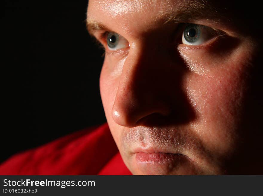 Thinking man in a red shirt in dark