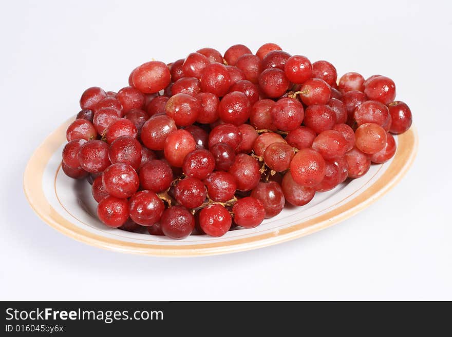 A plate of grapes isolated on white background. A plate of grapes isolated on white background