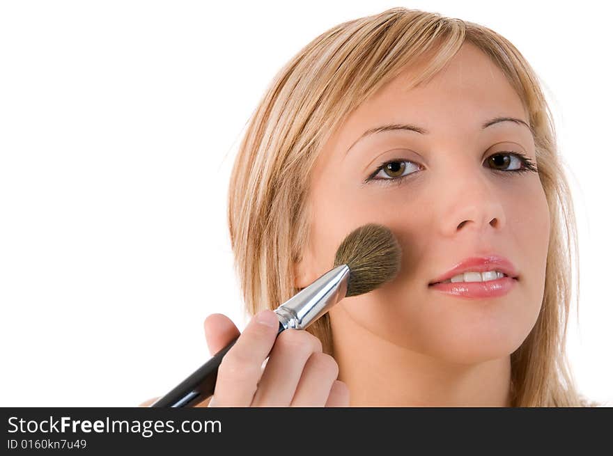 Pretty young woman applying make up. Isolated on white background