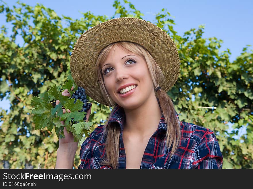 Closeup portrait of a happy young peasant woman among the vineyards