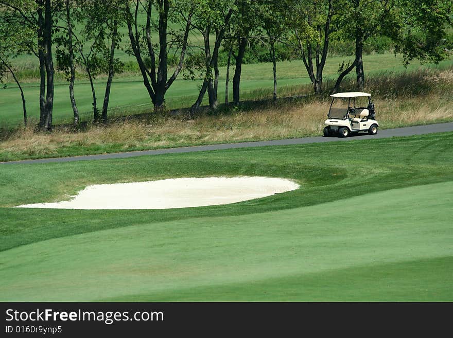 Golf cart parked near a sand trap