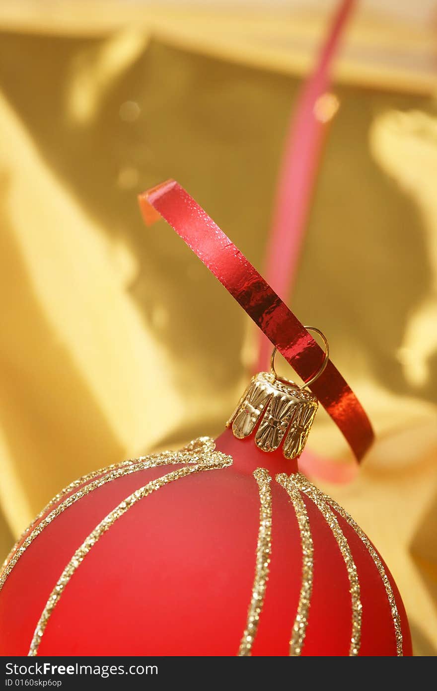 Christmas red ball on golden background.