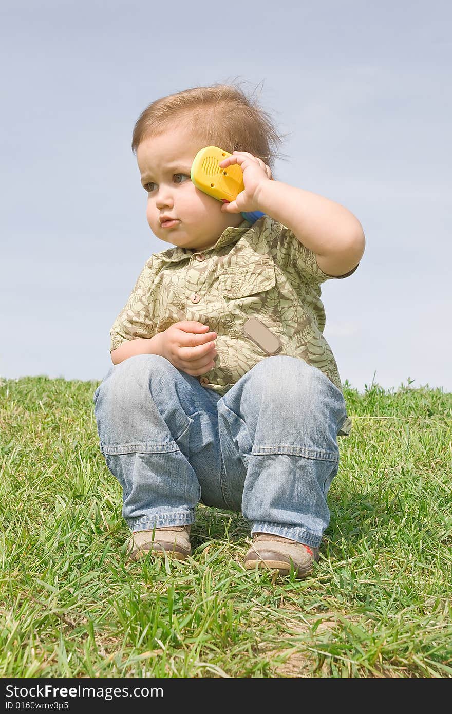 Little boy holding a toy cellphone near his ear. Little boy holding a toy cellphone near his ear