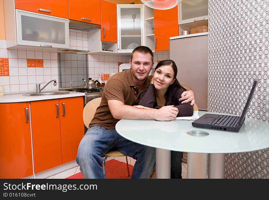 Casual couple with laptop in modern kitchen. Casual couple with laptop in modern kitchen