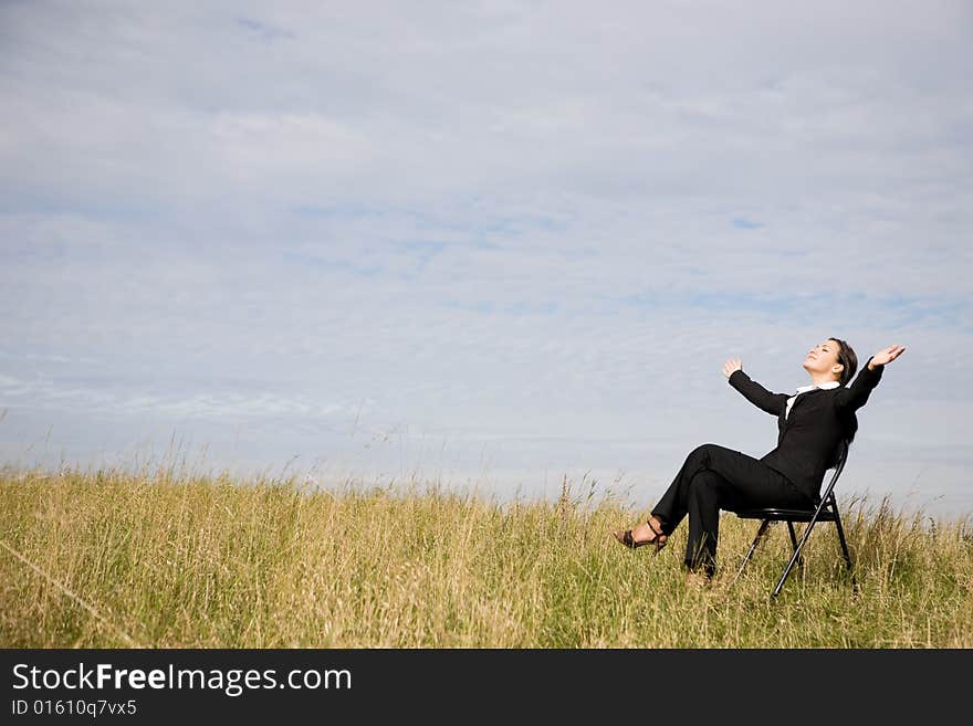 Attractive brunette businesswoman relaxing on meadow. Attractive brunette businesswoman relaxing on meadow