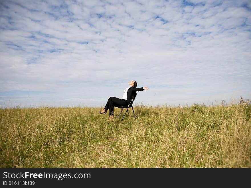 Attractive brunette businesswoman relaxing on meadow. Attractive brunette businesswoman relaxing on meadow