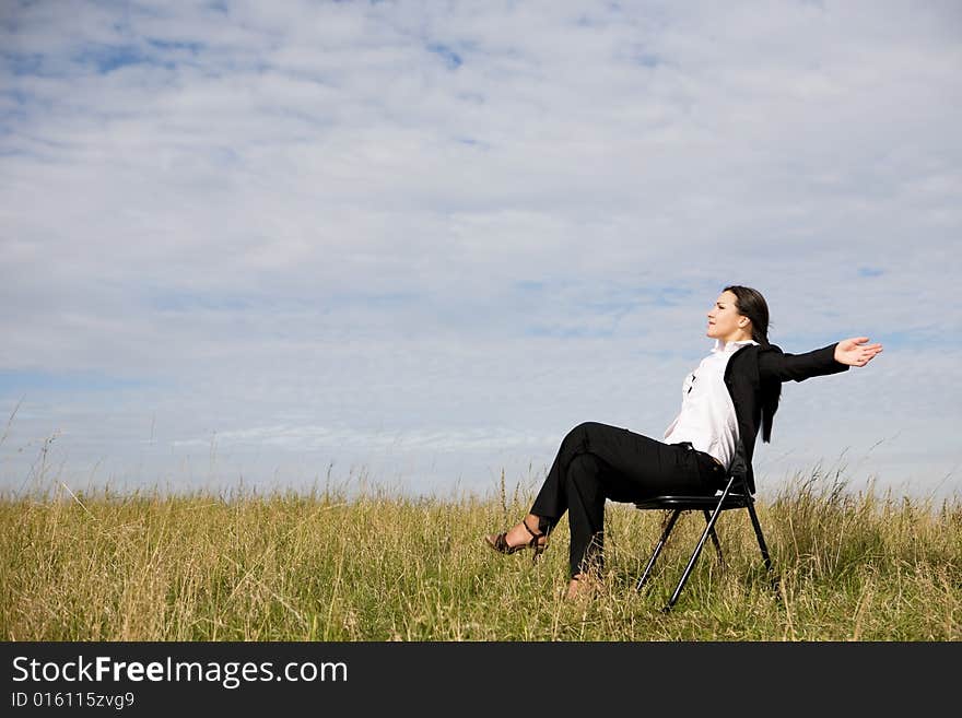 Attractive brunette businesswoman relaxing on meadow. Attractive brunette businesswoman relaxing on meadow