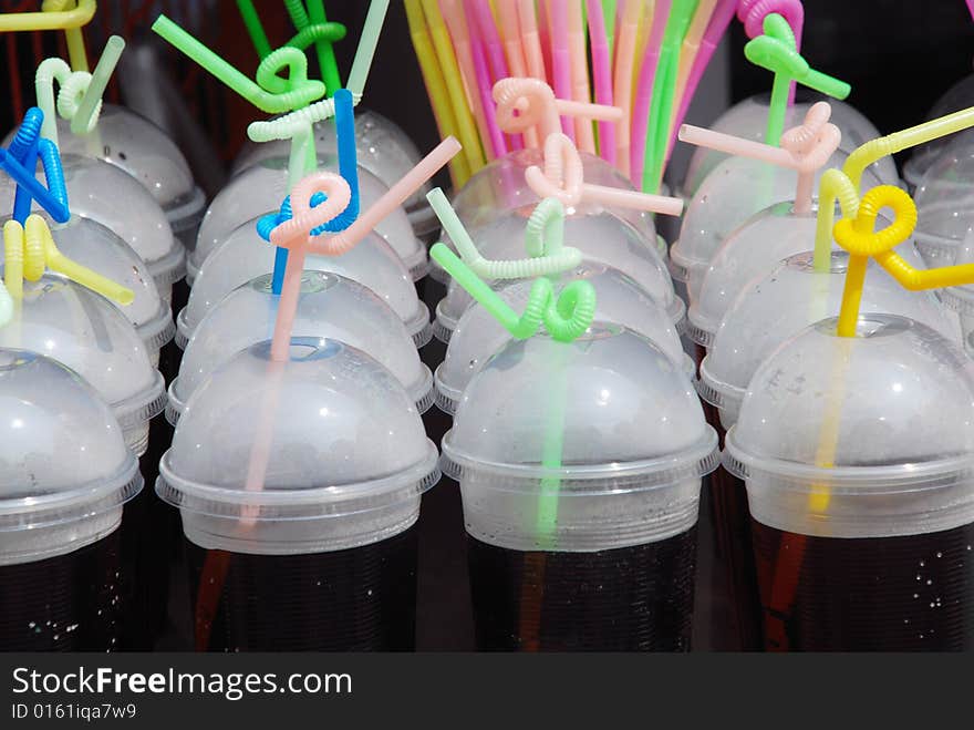 The fresh cold drink in transparent plastic cup with curving straws. The fresh cold drink in transparent plastic cup with curving straws.