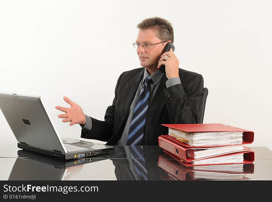 Business man at the office, working with mobile and laptop.