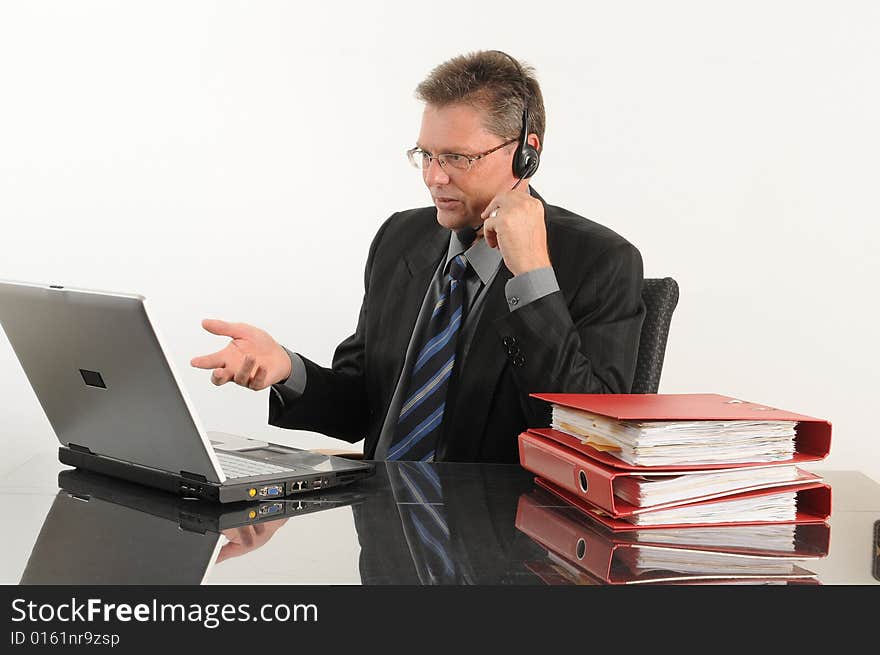 Business man at the office, working with mobile and laptop.