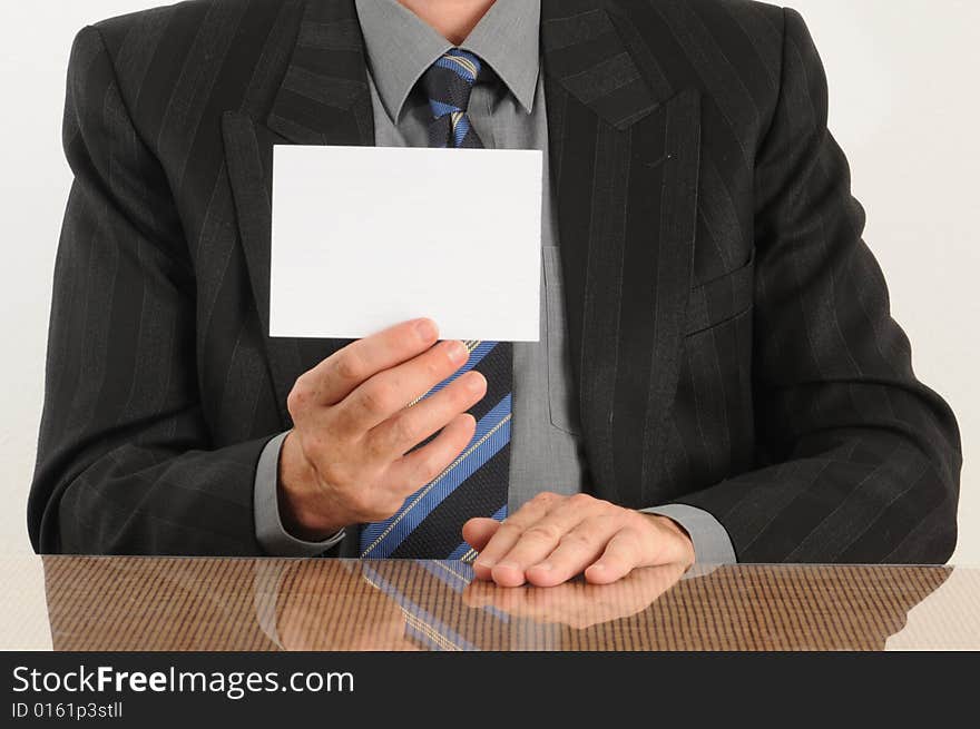 Business man holding a blank card in hand, wearing jacket and tie.