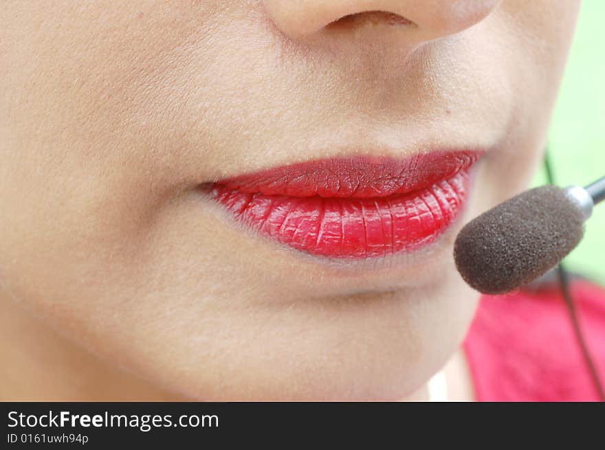 Lady talking on a head set microphone being helpful. Lady talking on a head set microphone being helpful