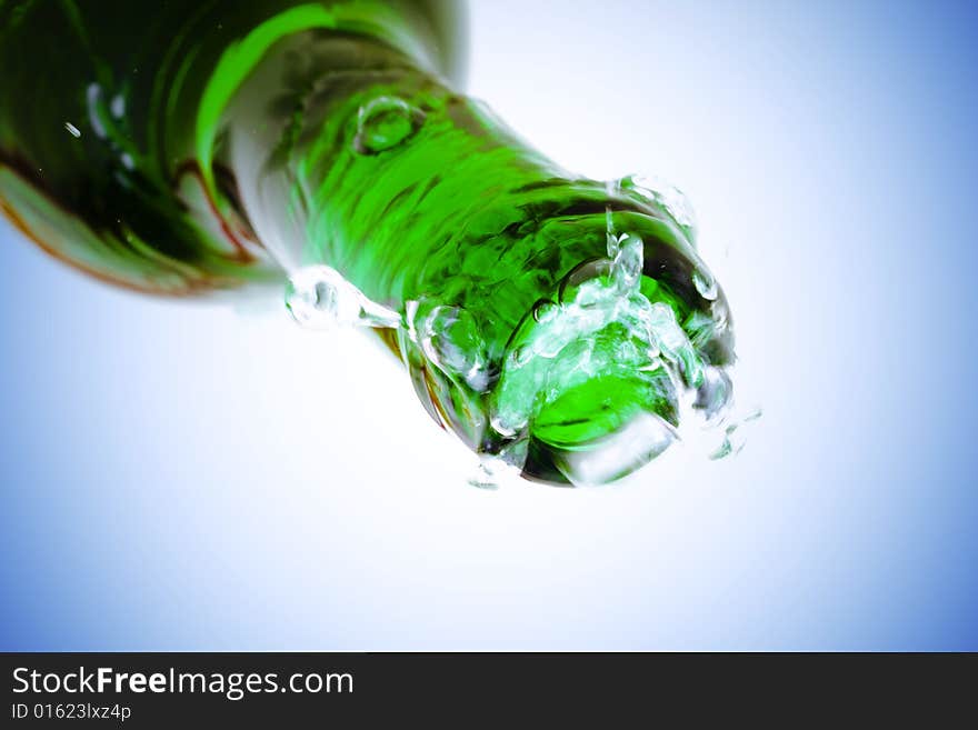 Water splash over bottle on blue background