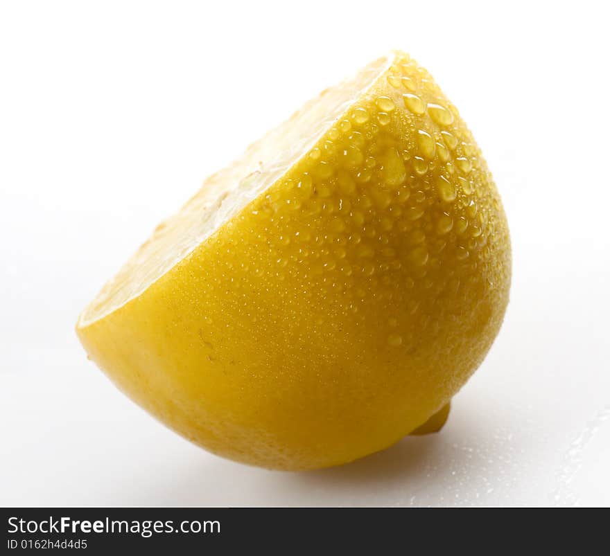 Sliced lemon with water drops on grey