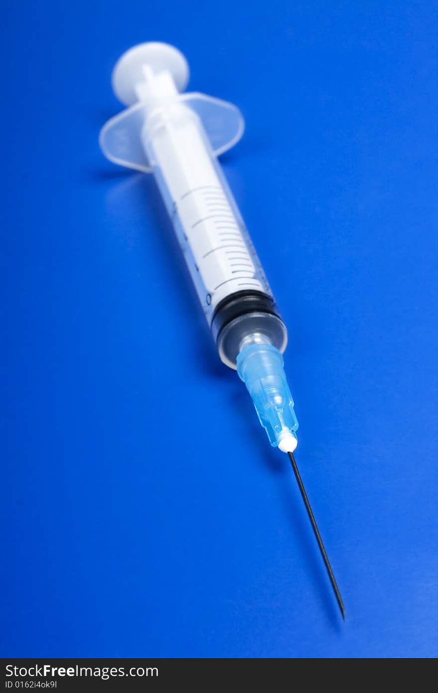 Syringe on blue