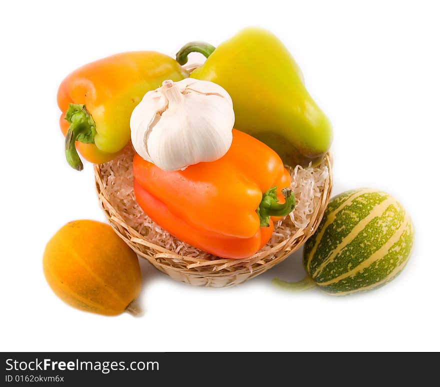 Sweet beautiful pepper garlic decorative pumpkins in basket on white background