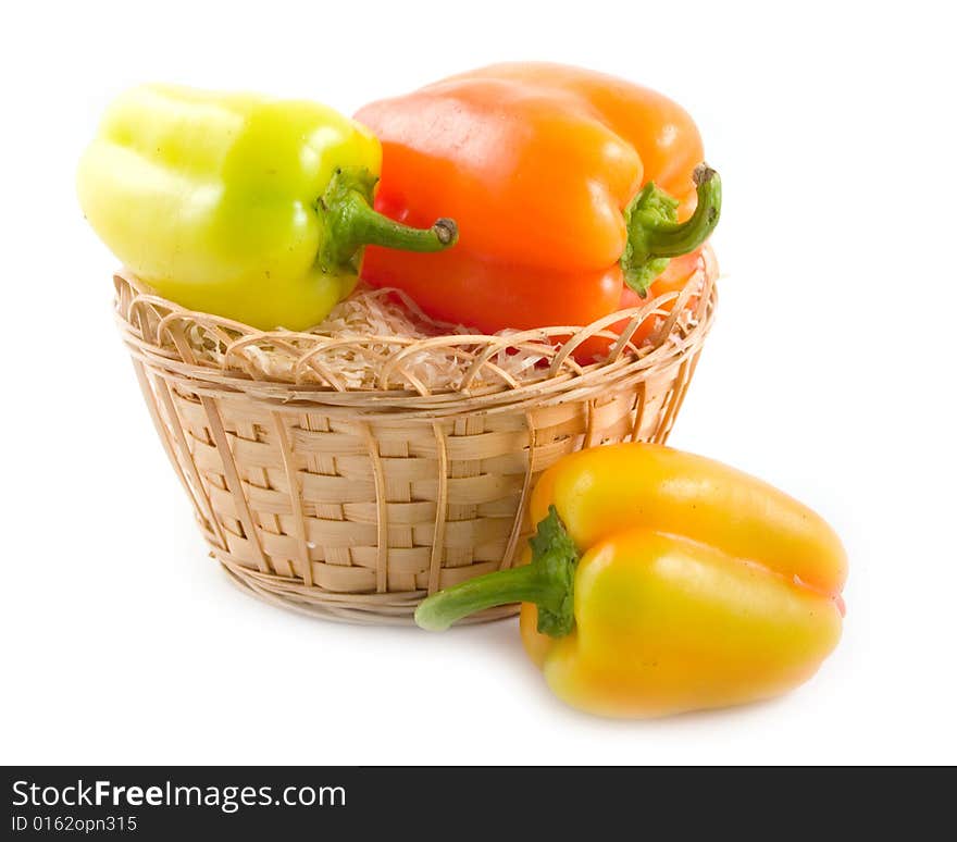 Red green yellow sweet beautiful pepper in basket on white background