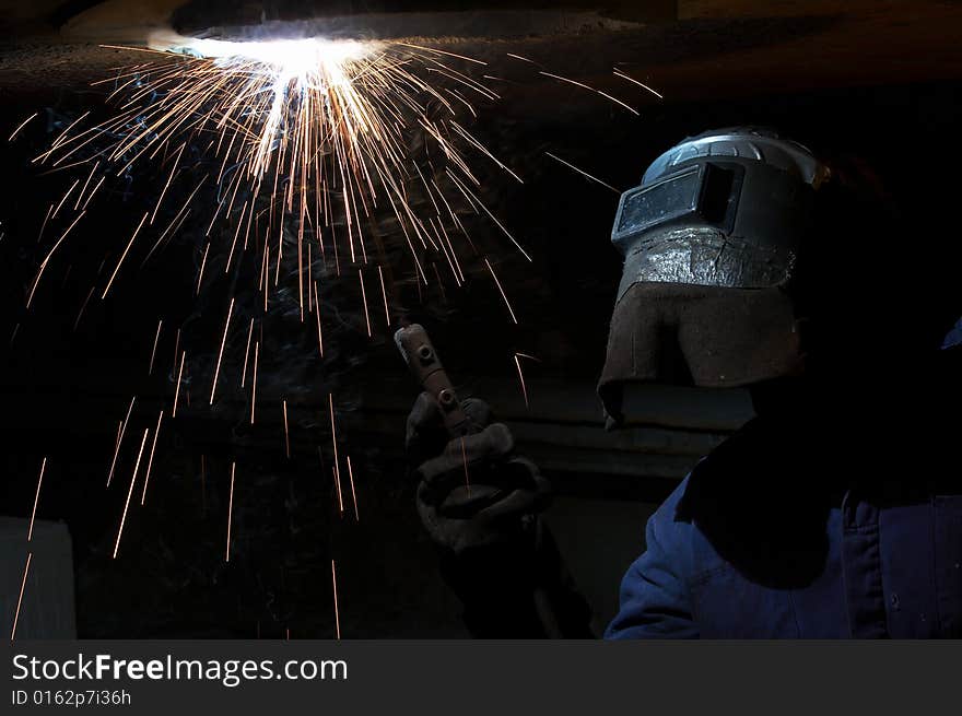 A welder working at shipyard at night. A welder working at shipyard at night